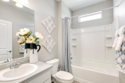 A modern bathroom decorated in white accents with a bathtub and shower combination.