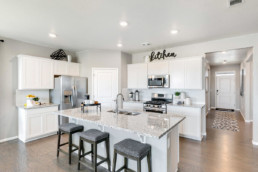 Large open concept kitchen with new appliances and an island with breakfast bar.