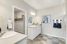 A large master ensuite featuring two vanities with two sinks an a large walk in closet.