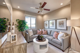 A comfortable family room with grey sectional and decorative throw pillows with a round coffee table.