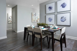 A large dining room with a modern table and colorful artwork.