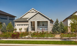 A beautiful new home with attached garage, a front veranda, and contemporary stonework on the exterior.