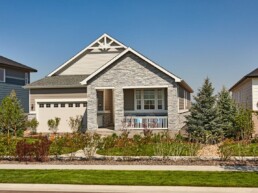 A beautiful new home with attached garage, a front veranda, and contemporary stonework on the exterior.