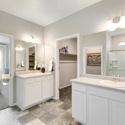 A large master ensuite featuring two vanities with two sinks an a large walk in closet.